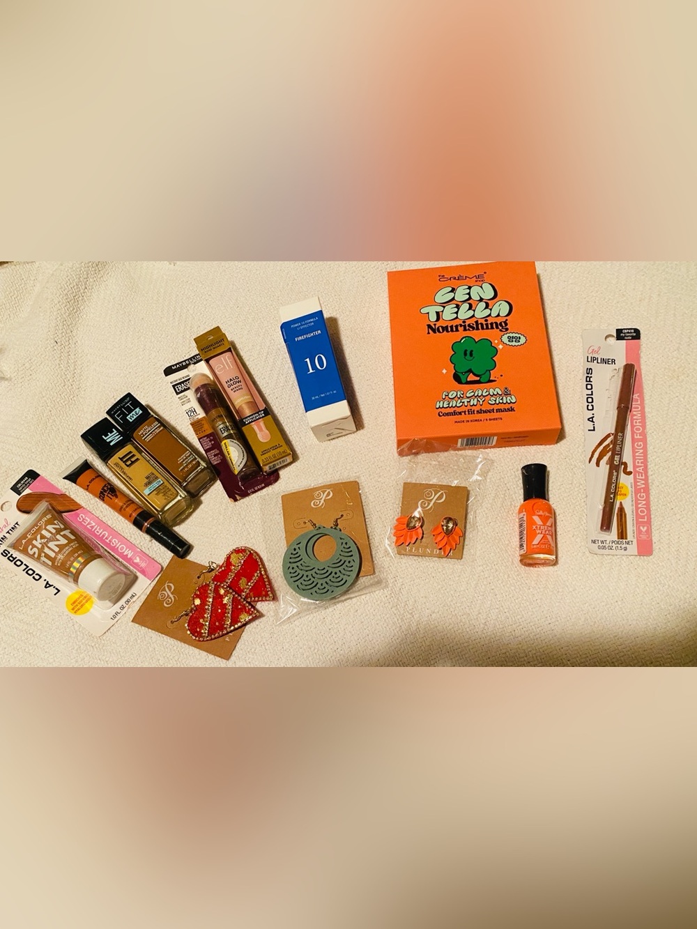 Bundle of Maybelline makeup assortment of earrings, skin care, nail polish